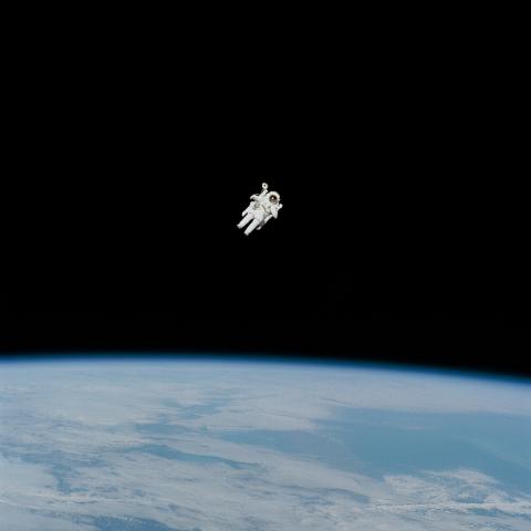 Astronaut in spacesuit floating in the space with Earth below them